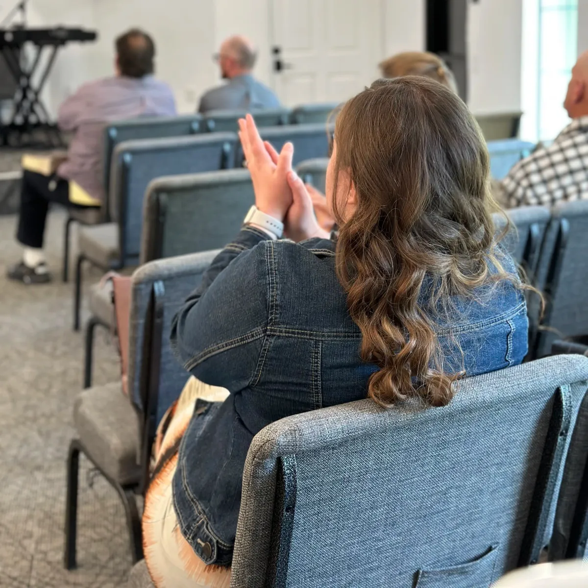 A woman clapping in worship during a service at The Pentecostals of Cody